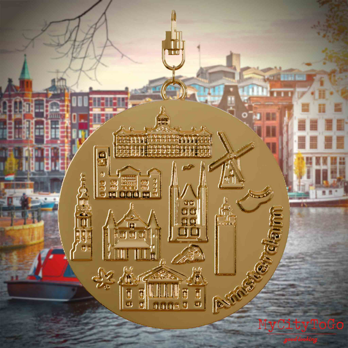 Halskette mit Drehwirbel und Rückseite eines vergoldeten Schmuckanhängers, auf dem Reliefs bekannter Sehenswürdigkeiten der Stadt Amsterdam abgebildet sind. Den Hintergrund bildet eine Ansicht der Stadt Amsterdam.
