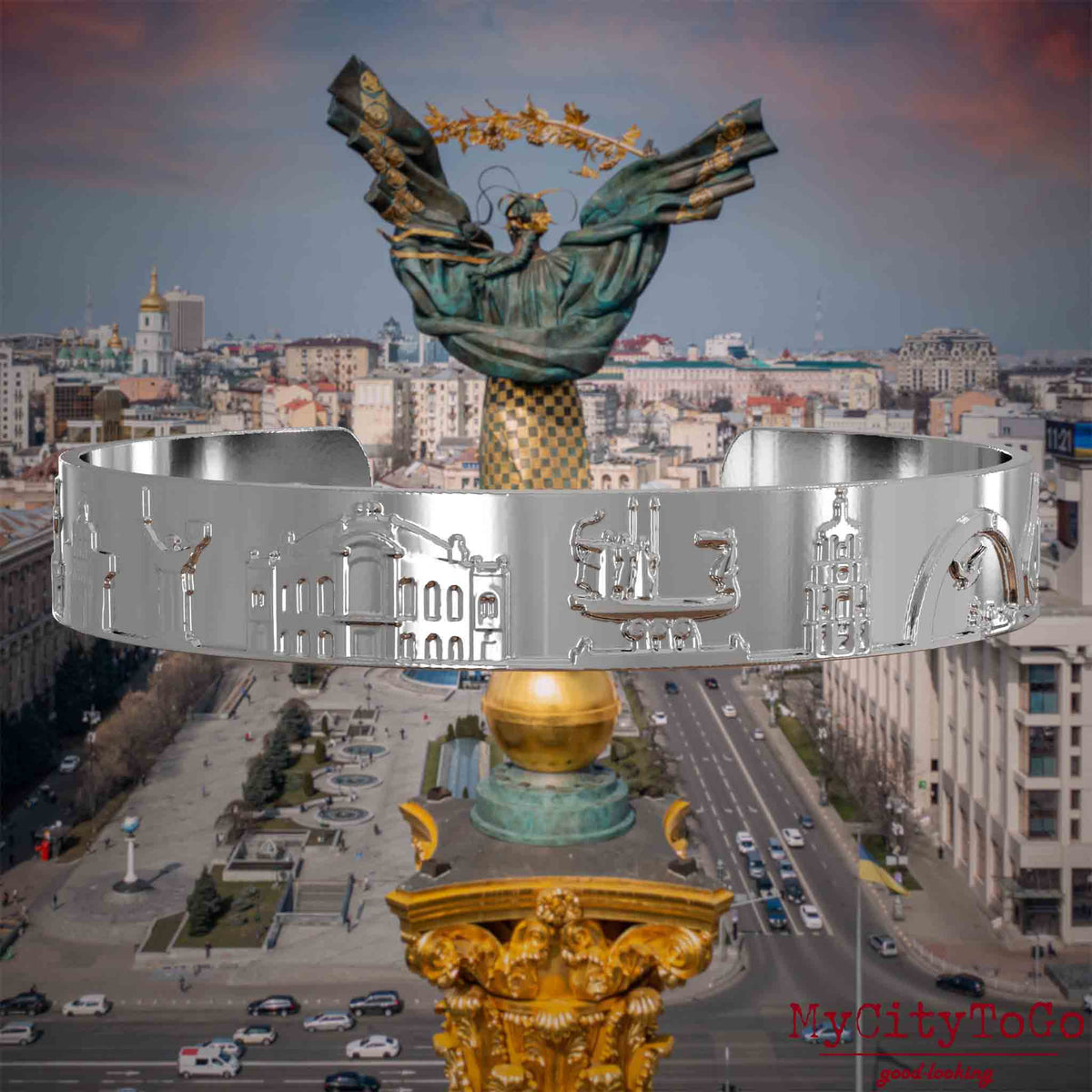 Versilberter Armreif mit Reliefs bekannter Sehenswürdigkeiten der Stadt Kiew. Den Hintergrund bildet eine Ansicht der Stadt Kiew.