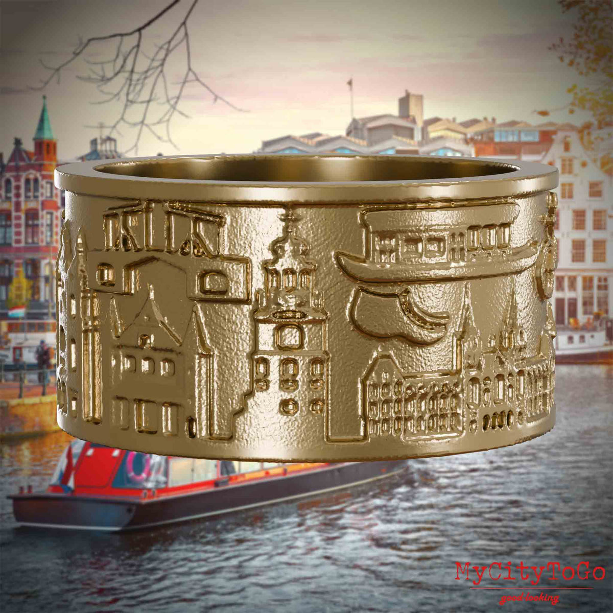 Ring aus vergoldetem Edelstahl mit Reliefs bekannter Sehenswürdigkeiten der Stadt Amsterdam. Den Hintergrund bildet eine Ansicht der Stadt Amsterdam.