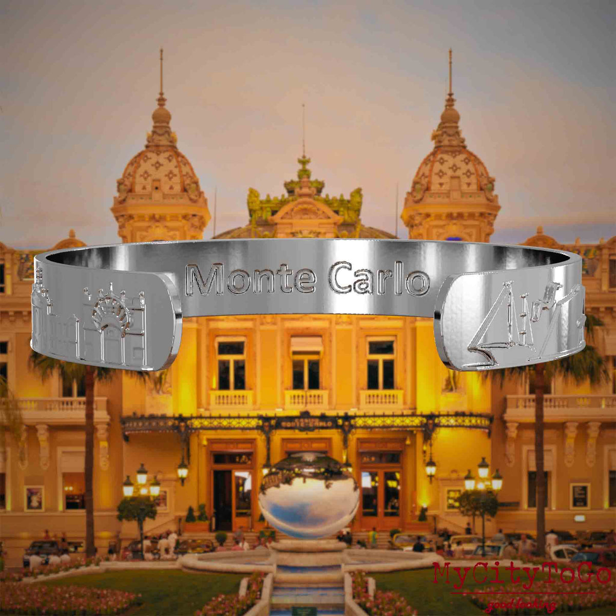 Innenseite eines silbernen Armreifs mit Reliefs bekannter Sehenswürdigkeiten der Stadt Monte Carlo und einer Gravur des Stadtnamens. Den Hintergrund bildet eine Ansicht der Stadt Monte Carlo.
