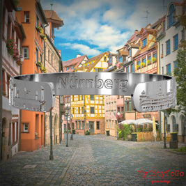 Innenseite eines silbernen Armreifs mit Reliefs bekannter Sehenswürdigkeiten der Stadt Nürnberg und einenr Gravur des Stadtnamens. Den Hintergrund bildet eine Ansicht der Stadt  Nuernberg.
