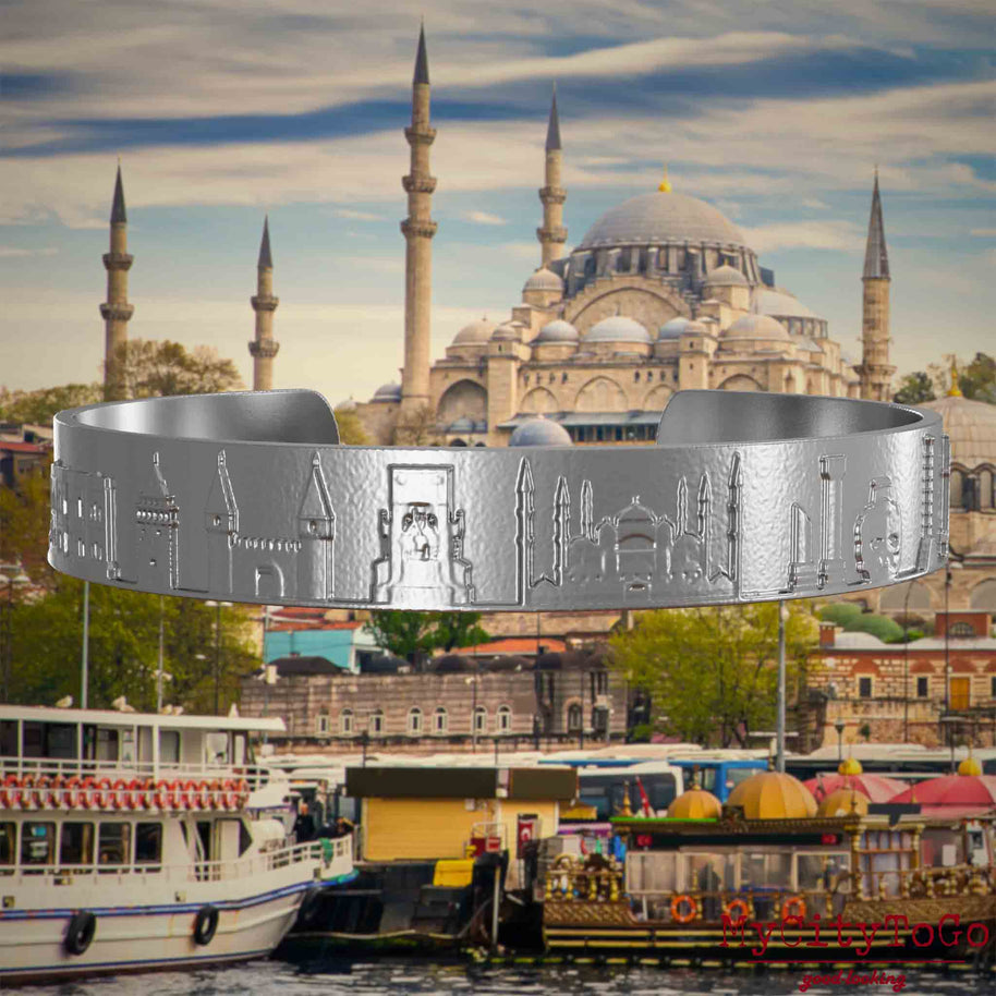 Armreif aus Edelstahl mit Reliefs bekannter Sehenswürdigkeiten der Stadt Istanbul. Den Hintergrund bildet eine Ansicht der Satdt Istanbul.