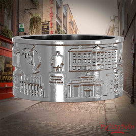 Silberner Ring mit Reliefs bekannter Sehenswürdigkeiten der Stadt Dublin. Den Hintergrund bildet eine Ansicht der Stadt Dublin.