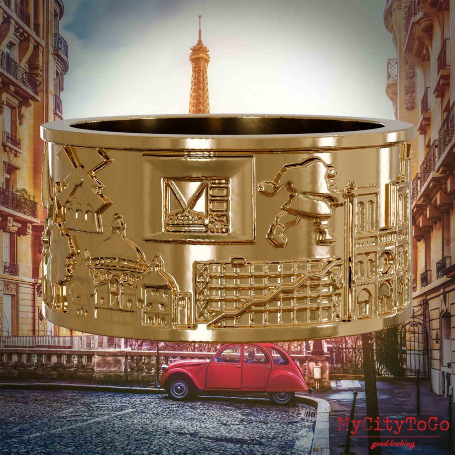 Vergoldeter Ring mit Reliefs bekannter Sehenswürdigkeiten der Stadt Paris. Den Hintergrund bildet eine Ansicht der Stadt Paris.