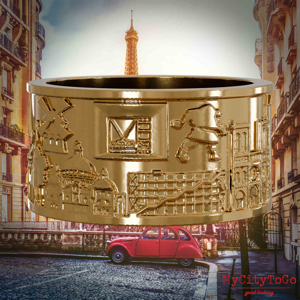 Vergoldeter Ring mit Reliefs bekannter Sehenswürdigkeiten der Stadt Paris. Den Hintergrund bildet eine Ansicht der Stadt Paris.