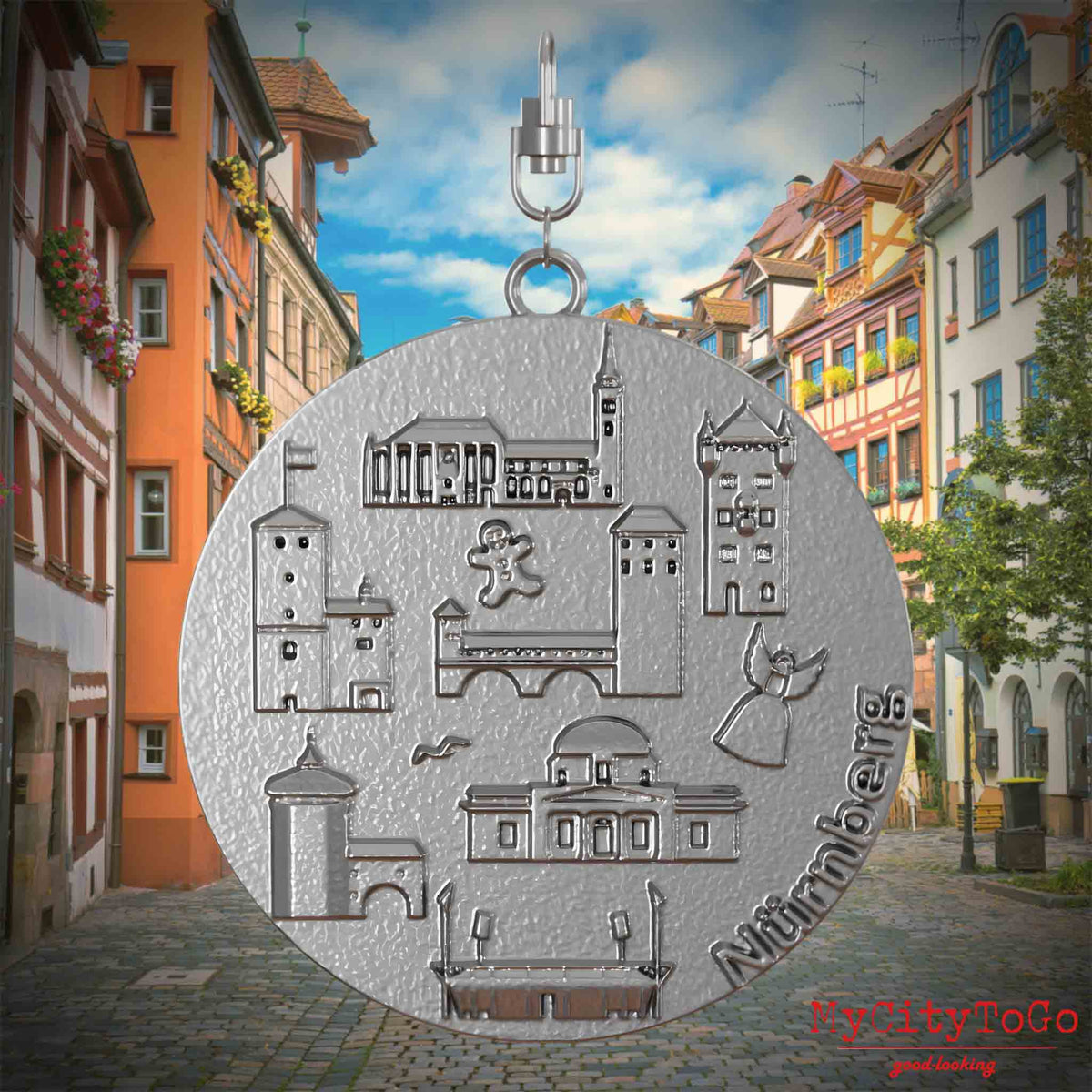 Halskette mit Drehwirbel und Rückseite eines Schmuckanhängers aus Edelstahl, auf dem Reliefs bekannter Sehenswürdigkeiten der Stadt Nuernberg abgebildet sind. Den Hintergrund bildet eine Ansicht der Stadt Nuernberg.
