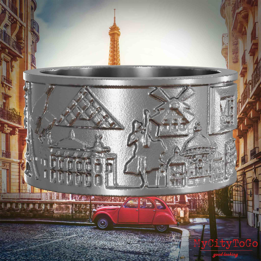 Ring aus Edelstahl mit Reliefs bekannter Sehenswürdigkeiten der Stadt Paris. Den Hintergrund bildet eine Ansicht der Stadt Paris.