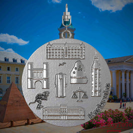 Halskette mit Drehwirbel und Rückseite eines Schmuckanhängers aus Edelstahl, auf dem Reliefs bekannter Sehenswürdigkeiten der Stadt Karlsruhe abgebildet sind. Den Hintergrund bildet eine Ansicht der Stadt Karlsruhe .
