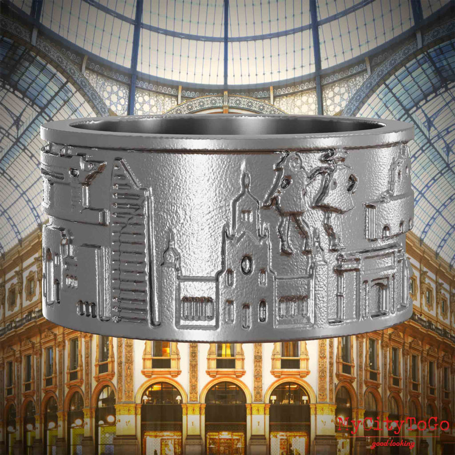 Ring aus Edelstahl mit Reliefs bekannter Sehenswürdigkeiten der Stadt Mailand. Den Hintergrund bildet eine Ansicht der Stadt Mailand.