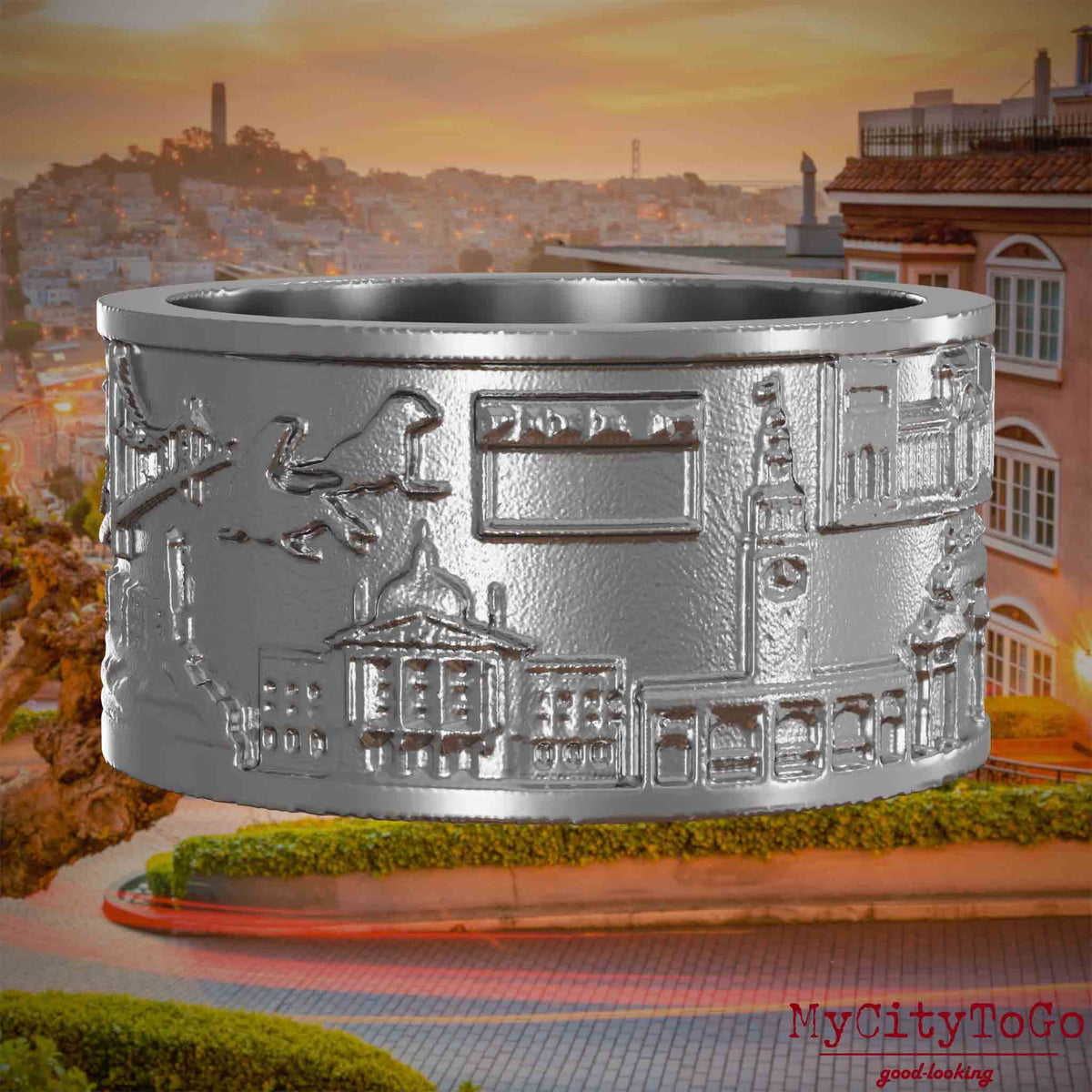 Ring aus Edelstahl mit Reliefs bekannter Sehenswürdigkeiten der Stadt San Francisco. Den Hintergrund bildet eine Ansicht der Stadt San Francisco.