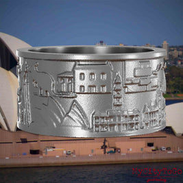Ring aus Edelstahl mit Reliefs bekannter Sehenswürdigkeiten der Stadt Sydney. Den Hintergrund bildet eine Ansicht der Stadt Sydney.
