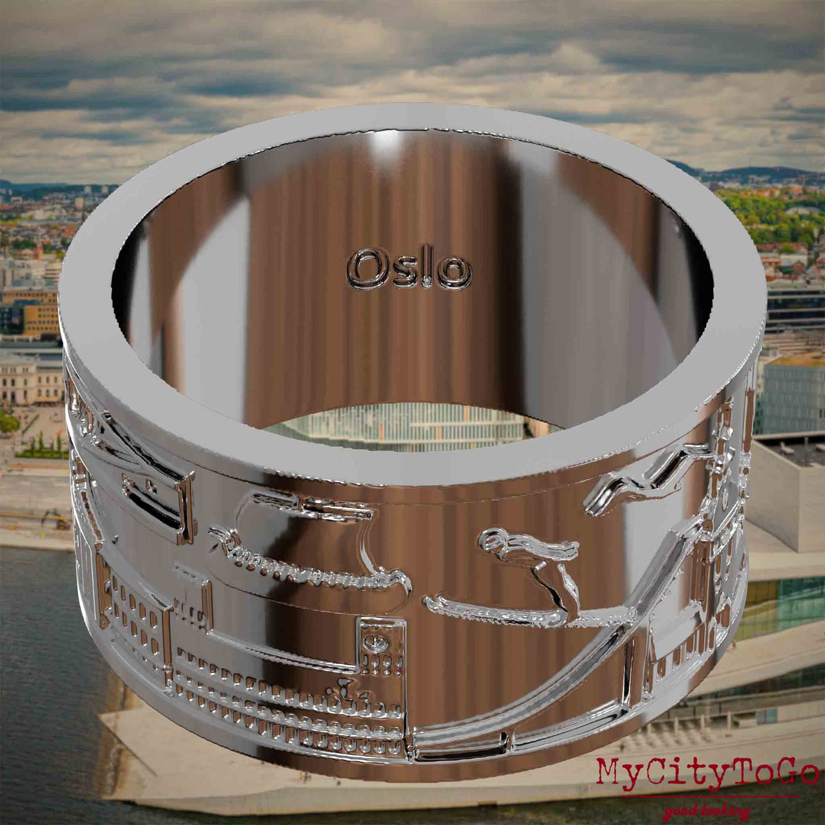 Versilberter Ring mit Reliefs bekannter Sehenswürdigkeiten der Stadt Oslo und einer Gravur des Stadtnamens auf der Innenseite. Den Hintergrund bildet eine Ansicht der Stadt Oslo.