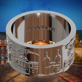Versilberter Ring mit Reliefs bekannter Sehenswürdigkeiten der Stadt Heidelberg und einer Gravur des Stadtnamens auf der Innenseite. Den Hintergrund bildet eine Ansicht der Stadt Heidelberg.