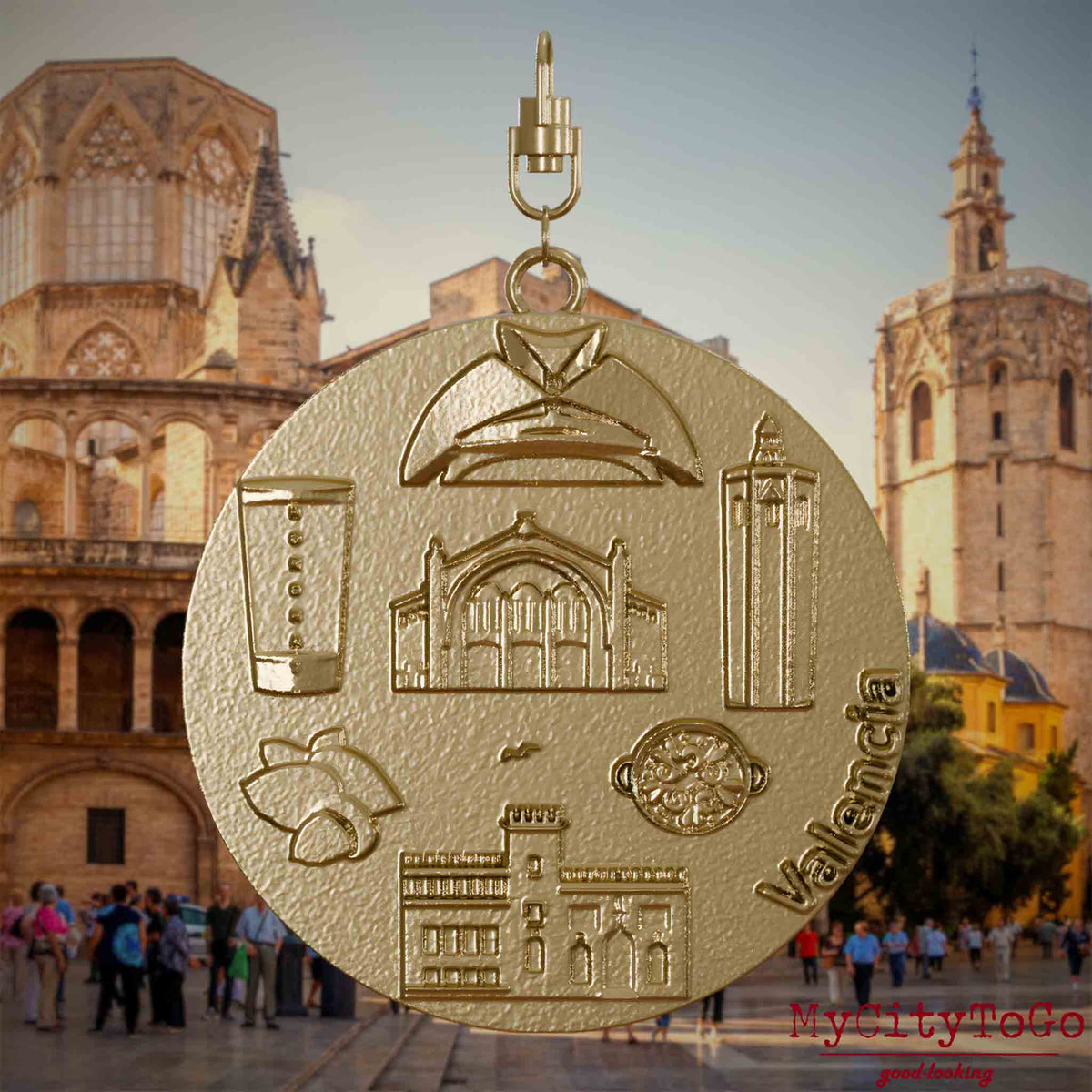Halskette mit Drehwirbel und Vorderseite eines Schmuckanhängers aus vergoldetem Edelstahl, auf dem Reliefs bekannter Sehenswürdigkeiten der Stadt Valencia abgebildet sind. Den Hintergrund bildet eine Ansicht der Stadt Valencia.
