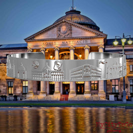 Versilberter Armreif mit Reliefs bekannter Sehenswürdigkeiten der Stadt Wiesbaden. Den Hintergrund bildet eine Ansicht der Stadt Wiesbaden.