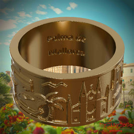 Ring aus vergoldetem Edelstahl mit Reliefs bekannter Sehenswürdigkeiten der Stadt Palma de Mallorca und einer Gravur des Stadtnamens auf der Innenseite. Den Hintergrund bildet eine Ansicht der Stadt Palma de Mallorca.