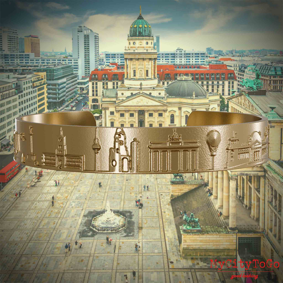 Vergoldeter Armreif aus Edelstahl mit Reliefs bekannter Sehenswürdigkeiten der Stadt Berlin. Den Hintergrund bildet eine Ansicht der Stadt Berlin. 