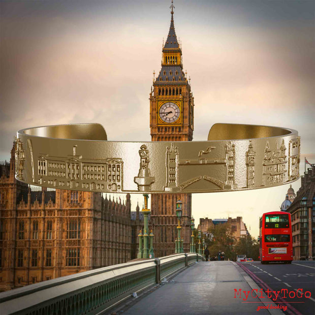 Amreif aus vergoldetem Edelstahl mit Reliefs bekannter Sehenswürdigkeiten der Stadt London. Den Hintergrund bildet eine Ansicht der Stadt London.