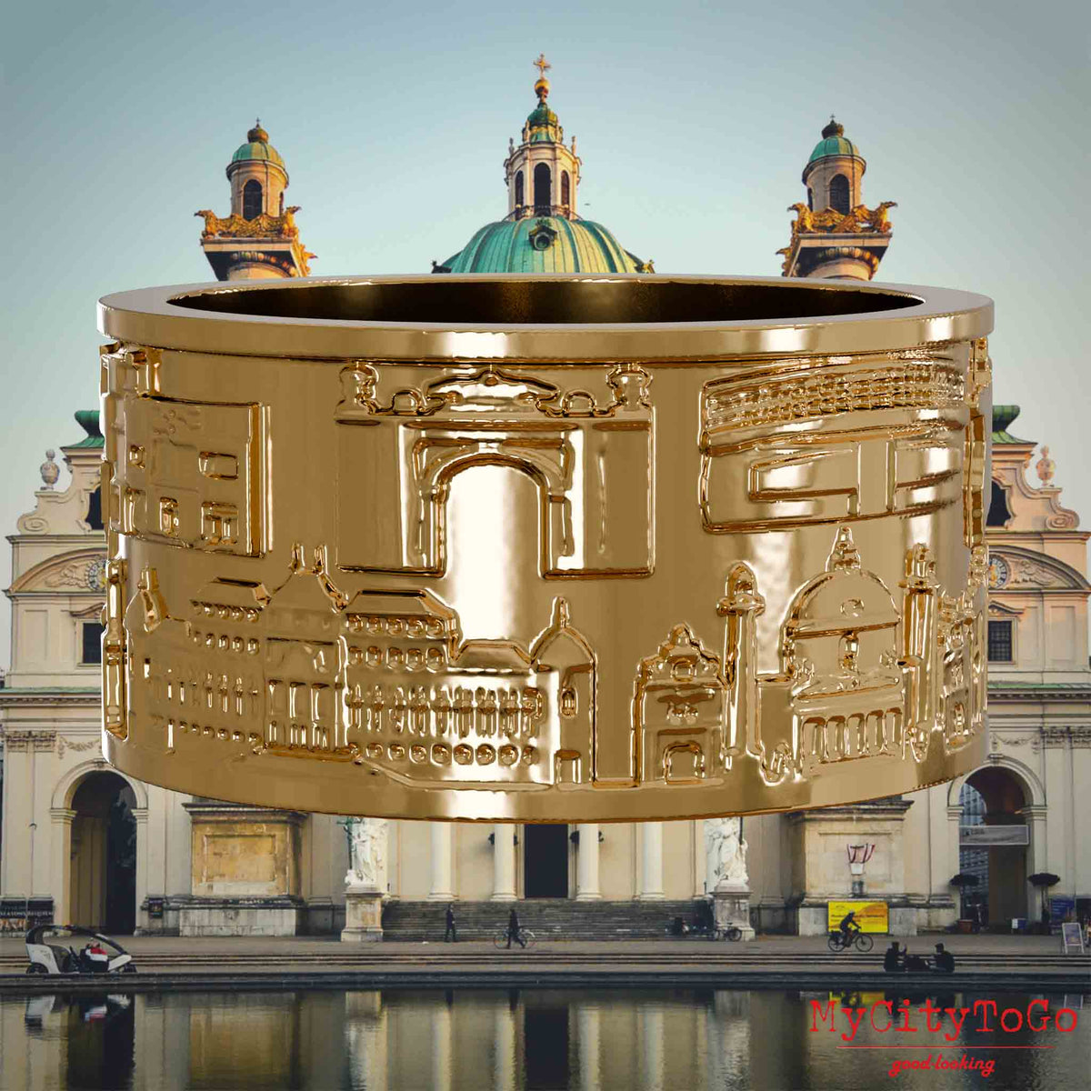 Vergoldeter Ring mit Reliefs bekannter Sehenswürdigkeiten der Stadt Wien. Den Hintergrund bildet eine Ansicht der Stadt Wien.