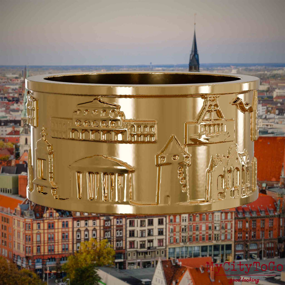 Vergoldeter Ring mit Reliefs bekannter Sehenswürdigkeiten der Stadt Hannover. Den Hintergrund bildet eine Ansicht der Stadt Hannover.
