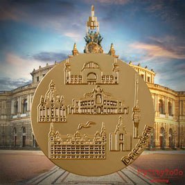 Halskette mit Drehwirbel und Rückseite eines vergoldeten Schmuckanhängers, auf dem Reliefs bekannter Sehenswürdigkeiten der Stadt Dresden abgebildet sind. Den Hintergrund bildet eine Ansicht der Stadt Dresden.
