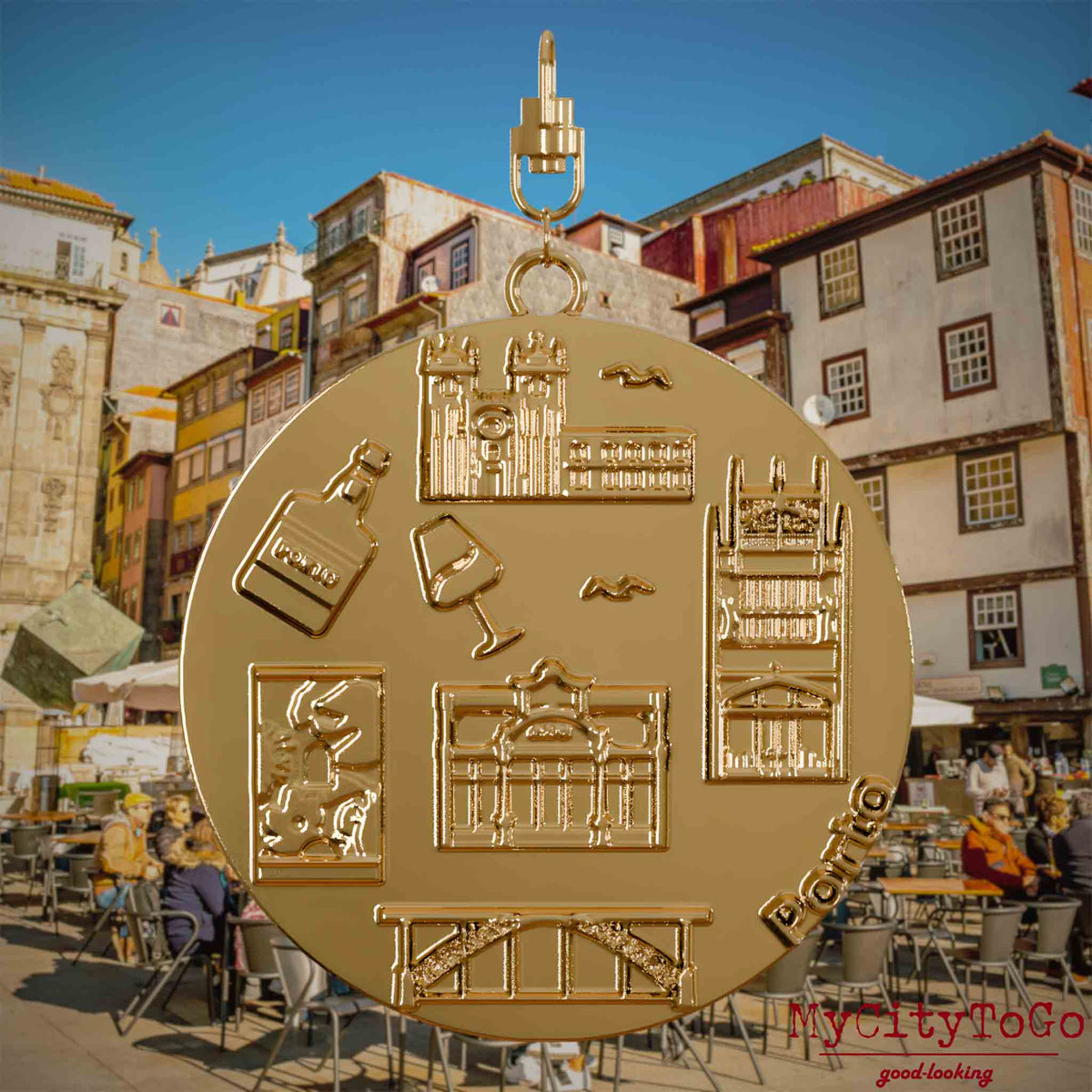 Halskette mit Drehwirbel und Rückseite eines Schmuckanhängers aus Edelstahl, auf dem Reliefs bekannter Sehenswürdigkeiten der Stadt Porto abgebildet sind. Den Hintergrund bildet eine Ansicht der Stadt Porto.
