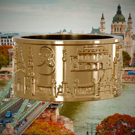 Vergoldeter Ring mit Reliefs bekannter Sehenswürdigkeiten der Stadt Budapest. Den Hintergrund bildet eine Ansicht der Stadt Budapest.