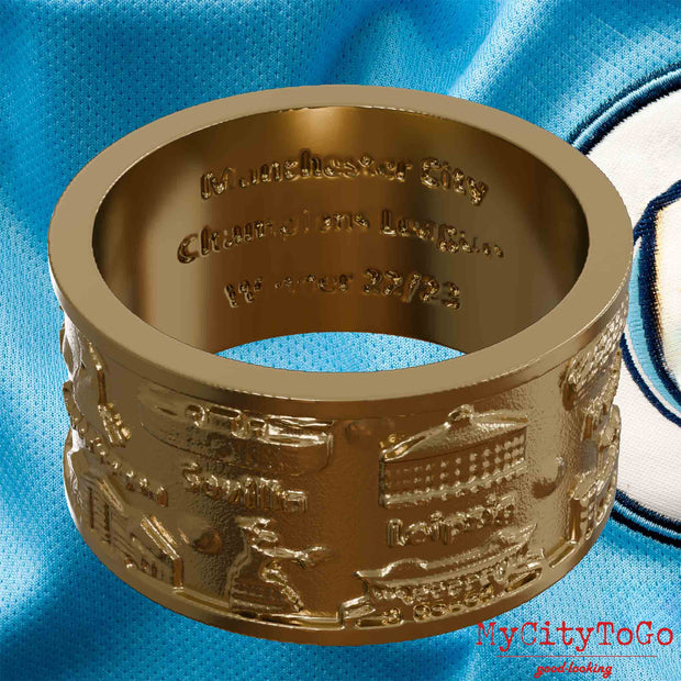 Ring aus vergoldetem Edelstahl mit Reliefs bekannter Sehenswürdigkeiten der Spielorte und Stadien der Champions-League-Saison 2022/23 von Manchester City und der Gravur "Manchester City Champions League Winner 22/23" auf der Innenseite