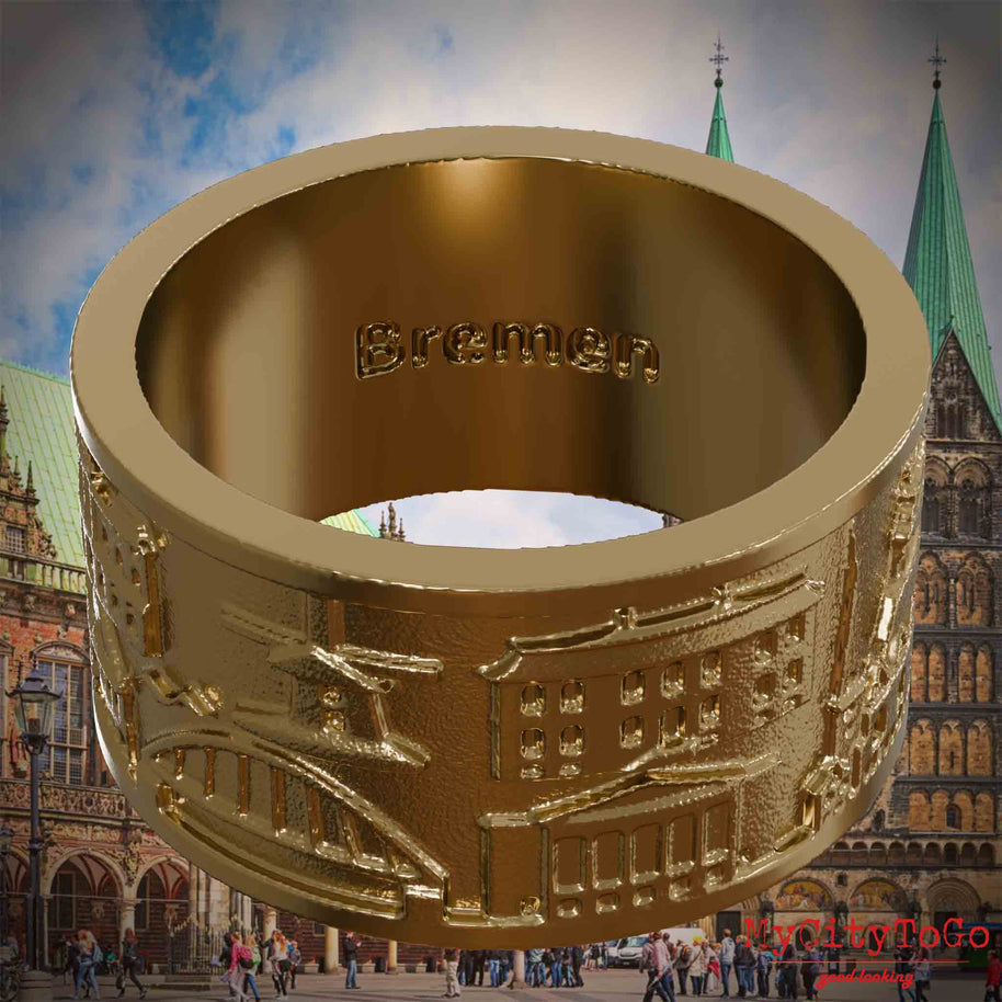 Ring aus vergoldetem Edelstahl mit Reliefs bekannter Sehenswürdigkeiten der Stadt Bremen und einer Gravur des Stadtnamens auf der Innenseite. Den Hintergrund bildet eine Ansicht der Stadt Bremen.