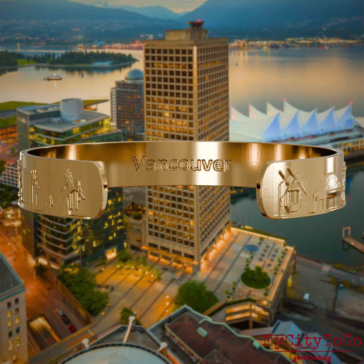 Innenseite eines vergoldeten Armreifs mit Reliefs bekannter Sehenswürdigkeiten der Stadt Vancouver und einer Gravur des Stadtnamens. Den Hintergrund bildet eine Ansicht der Stadt Vancouver.