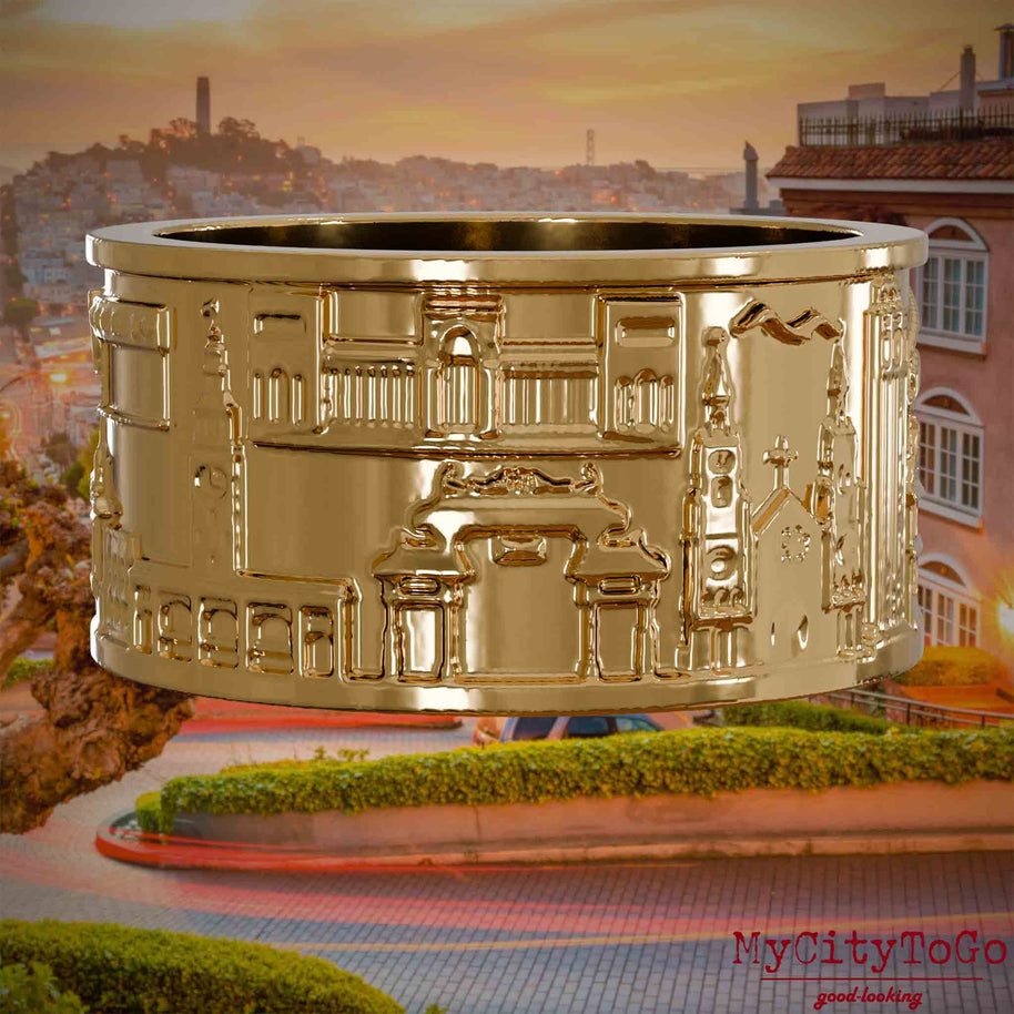 Vergoldeter Ring mit Reliefs bekannter Sehenswürdigkeiten der Stadt San Francisco. Den Hintergrund bildet eine Ansicht der Stadt San Francisco.