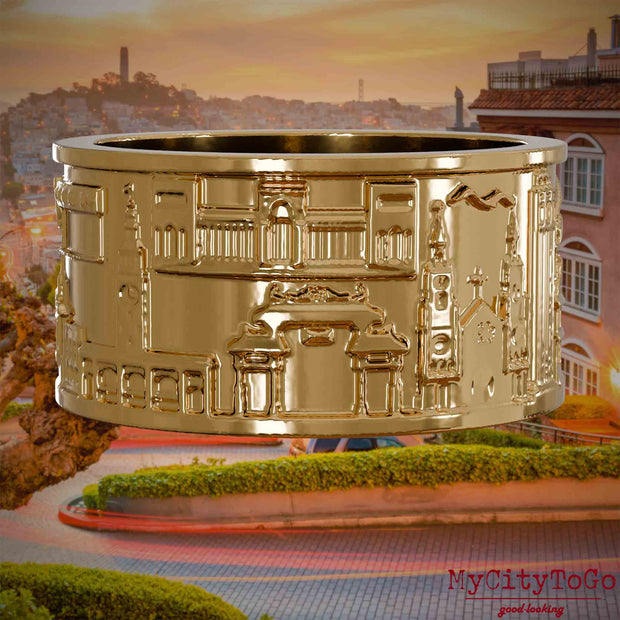 Vergoldeter Ring mit Reliefs bekannter Sehenswürdigkeiten der Stadt San Francisco. Den Hintergrund bildet eine Ansicht der Stadt San Francisco.