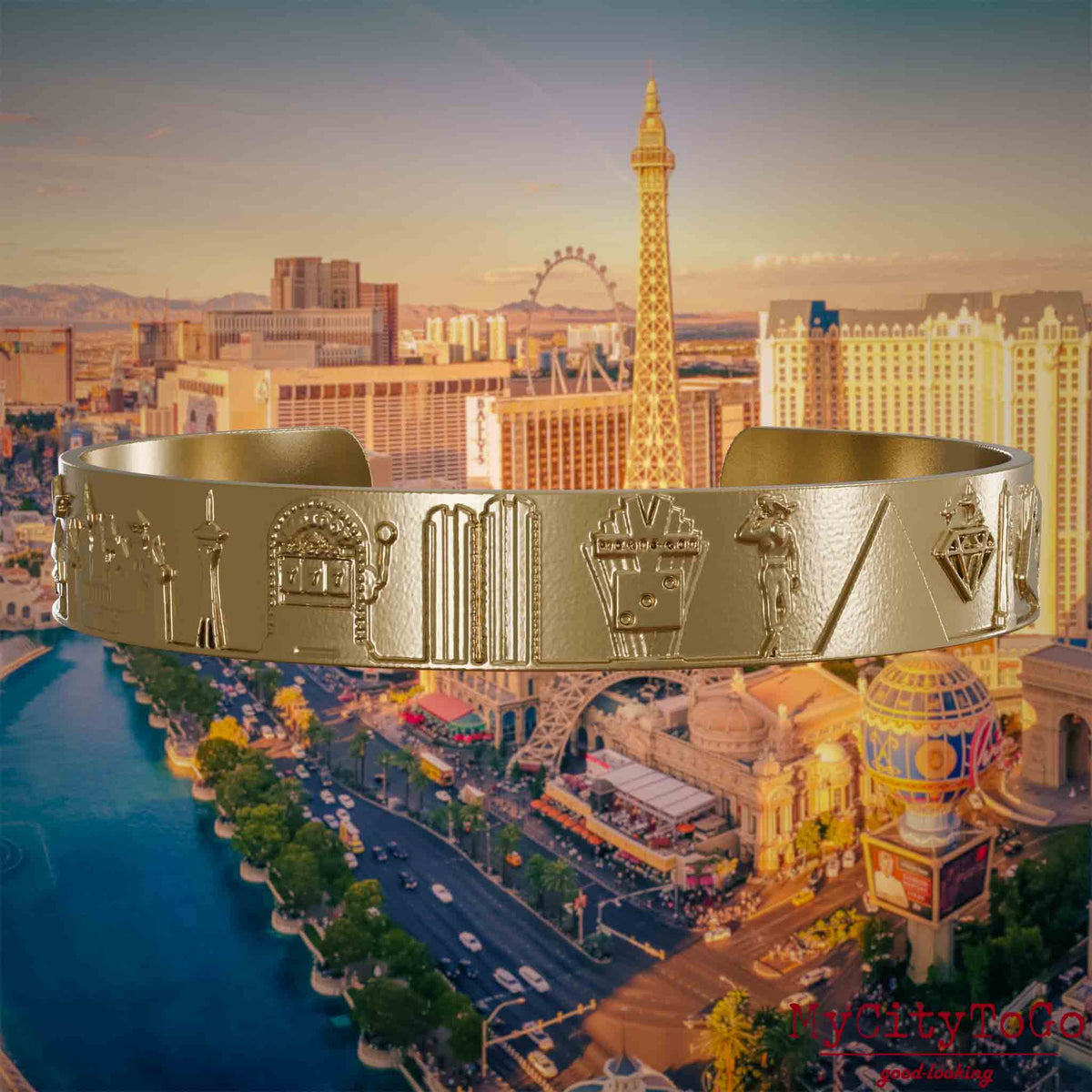 Armreif aus vergoldetem Edelstahl mit Reliefs bekannter Sehenswürdigkeiten der Stadt Las Vegas. Den Hintergrund bildet eine Ansicht der Stadt Las Vegas.