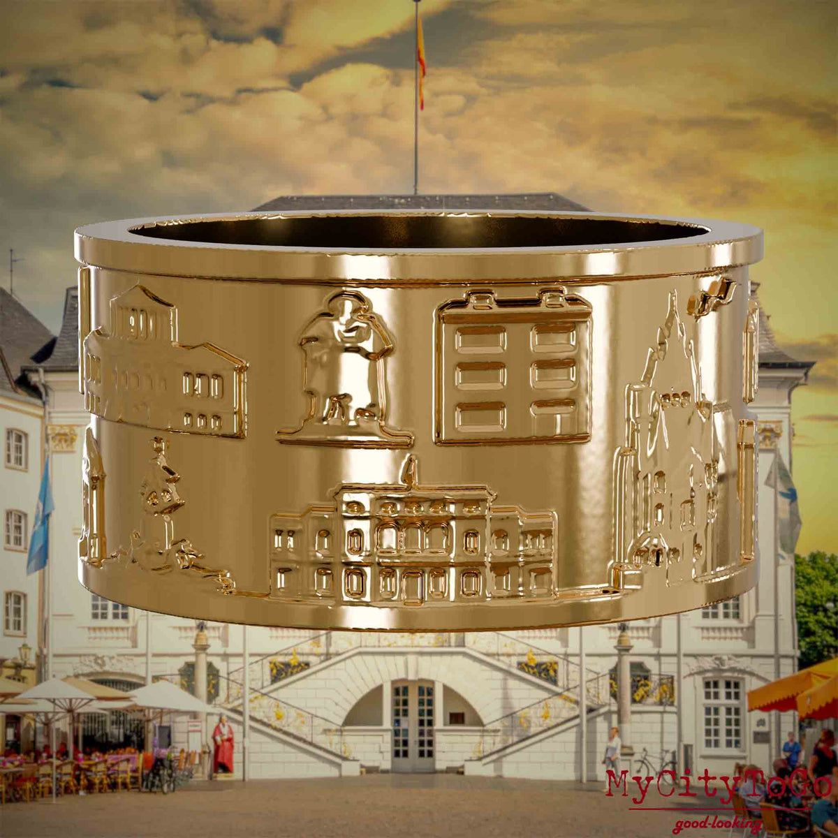 Vergoldeter Ring mit Reliefs bekannter Sehenswürdigkeiten der Stadt Bonn. Den Hintergrund bildet eine Ansicht der Stadt Bonn.
