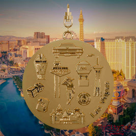 Halskette mit Drehwirbel und Rückseite eines vergoldeten Schmuckanhängers, auf dem Reliefs bekannter Sehenswürdigkeiten der Stadt Las Vegas abgebildet sind. Den Hintergrund bildet eine Ansicht der Stadt Las Vegas.