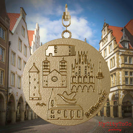 Halskette mit Drehwirbel und Vorderseite eines Schmuckanhängers aus vergoldetem Edelstahl, auf dem Reliefs bekannter Sehenswürdigkeiten der Stadt Muenster abgebildet sind. Den Hintergrund bildet eine Ansicht der Stadt Muenster.