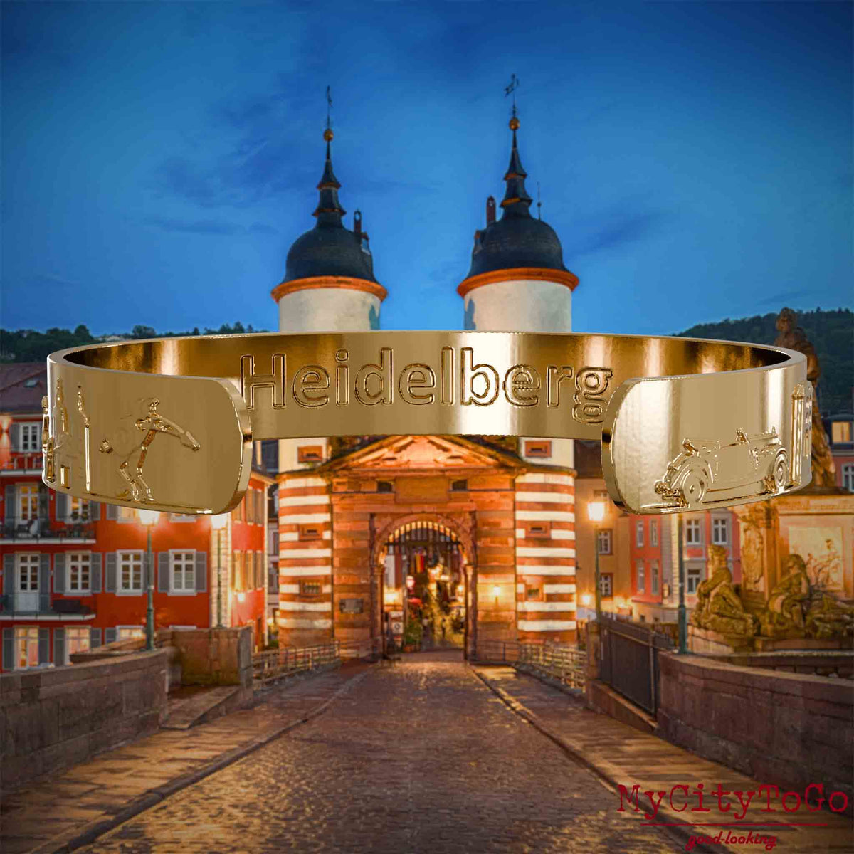 Innenseite eines vergoldeten Armreifs mit Reliefs bekannter Sehenswürdigkeiten der Stadt Heidelberg und einer Gravur des Stadtnamens. Den Hintergrund bildet eine Ansicht der Stadt Heidelberg.