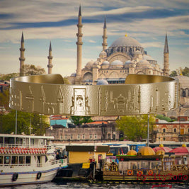 Armreif aus vergoldetem Edelstahl mit Reliefs bekannter Sehenswürdigkeiten der Stadt Istanbul. Den Hintergrund bildet eine Ansicht der Satdt Istanbul.