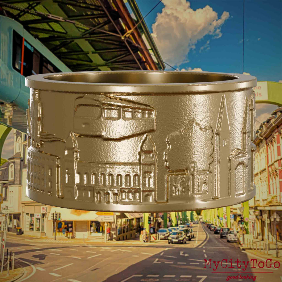 Ring aus vergoldetem Edelstahl mit Reliefs bekannter Sehenswürdigkeiten der Stadt Wuppertal. Den Hintergrund bildet eine Ansicht  der Stadt Wuppertal.