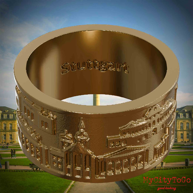 Ring aus vergoldetem Edelstahl mit Reliefs bekannter Sehenswürdigkeiten der Stadt Stuttgart und einer Gravur des Stadtnamens auf der Innenseite. Den Hintergrund bildet eine Ansicht der Stadt Stuttgart.