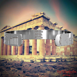 Innenseite eines silbernen Armreifs mit Reliefs bekannter Sehenswürdigkeiten der Stadt Athen und einer Gravur des Stadtnamens. Den Hintergrund bildet eine Ansicht der Stadt Athen.