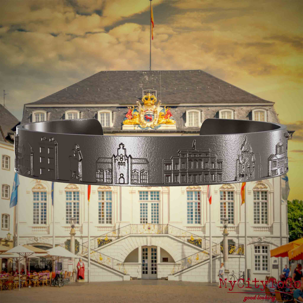 Armreif aus Titan mit Reliefs bekannter Sehenswürdigkeiten der Stadt Bonn. Den Hintergrund bildet eine Ansicht der Stadt Bonn.