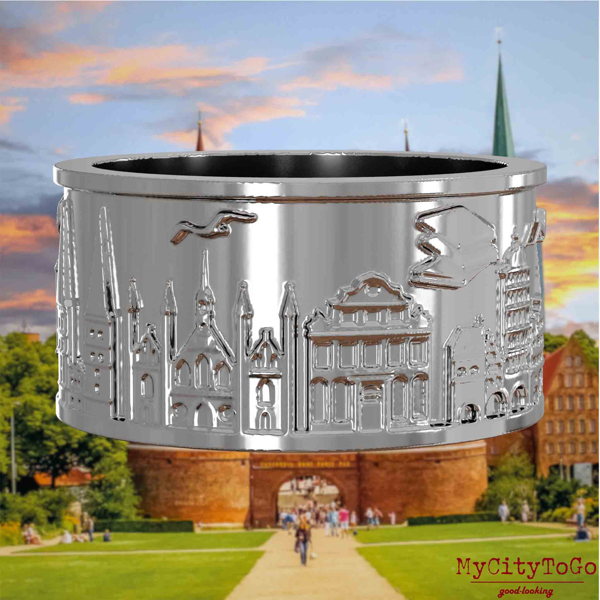 Silberner Ring mit Reliefs bekannter Sehenswürdigkeiten der Stadt Luebeck. Den Hintergrund bildet eine Ansicht der Stadt Luebeck.