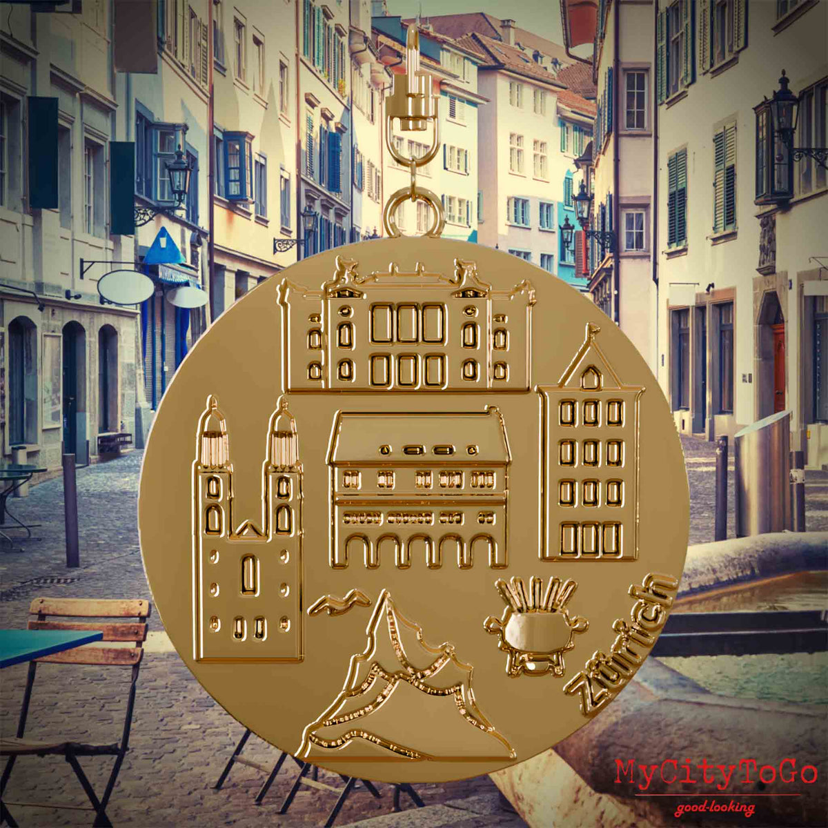 Halskette mit Drehwirbel und Vorderseite eines vergoldeten Schmuckanhängers, auf dem Reliefs bekannter Sehenswürdigkeiten der Stadt Zuerich abgebildet sind. Den Hintergrund bildet eine Ansicht der Stadt Zuerich.
