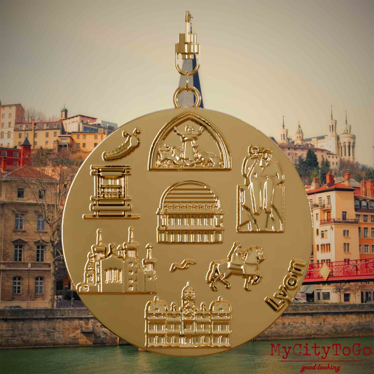 Halskette mit Drehwirbel und Rückseite eines vergoldeten Schmuckanhängers, auf dem Reliefs bekannter Sehenswürdigkeiten der Stadt Lyon abgebildet sind. Den Hintergrund bildet eine Ansicht der Stadt Lyon.
