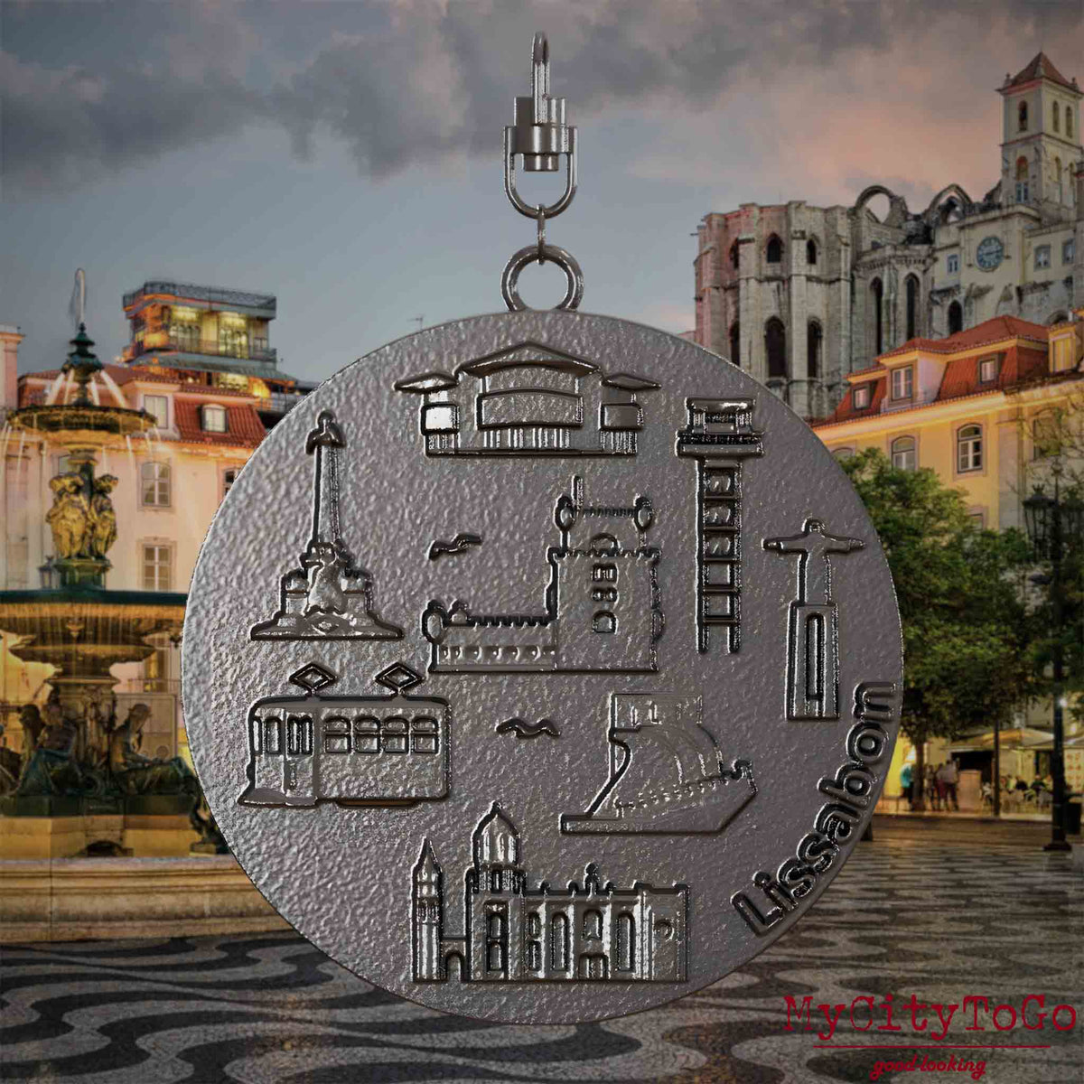 Halskette mit Drehwirbel und Vorderseite eines Schmuckanhängers aus Titan, auf dem Reliefs bekannter Sehenswürdigkeiten der Stadt Lissabon abgebildet sind. Den Hintergrund bildet eine Ansicht der Stadt Lissabon.
