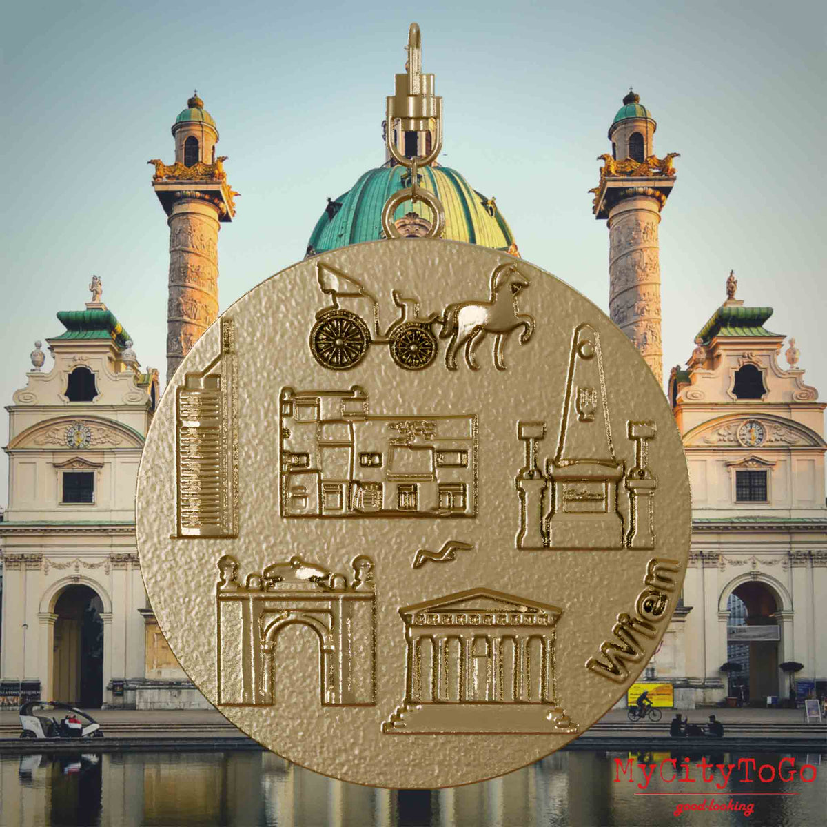 Halskette mit Drehwirbel und Vorderseite eines Schmuckanhängers aus vergoldetem Edelstahl, auf dem Reliefs bekannter Sehenswürdigkeiten der Stadt Wien abgebildet sind. Den Hintergrund bildet eine Ansicht der Stadt Wien.
