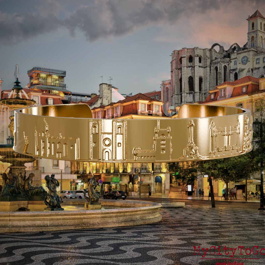 Vergoldeter Armreif mit Reliefs bekannter Sehenswürdigkeiten der Stadt Lissabon. Den Hintergrund bildet eine Ansicht der Stadt Lissabon.