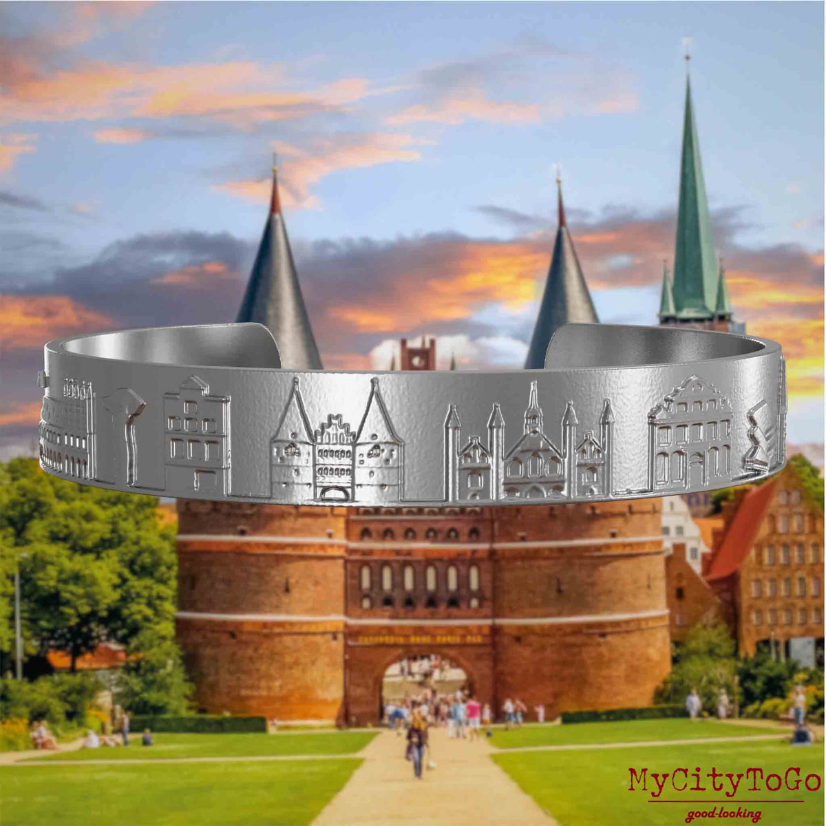 Armreif aus Edelstahl mit Reliefs bekannter Sehenswürdigkeiten der Stadt Luebeck. Den Hintergrund bildet eine Ansicht der Stadt Luebeck.