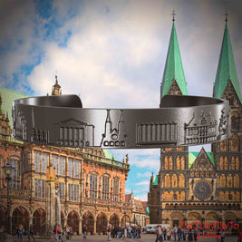 Armreif aus Titan mit Reliefs bekannter Sehenswürdigkeiten der Stadt Bremen. Den Hintergrund bildet eine Ansicht der Stadt Bremen.